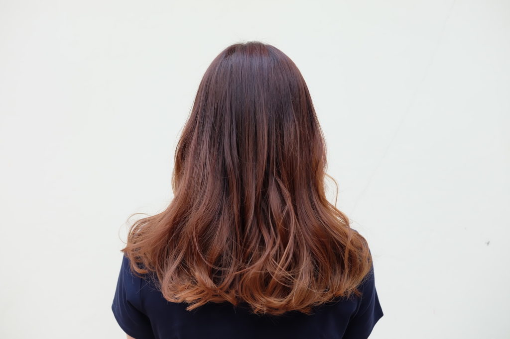wanita Asia dengan warna rambut cokelat terang menghadap ke belakang