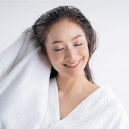 Wanita Asia sedang mengeringkan rambut