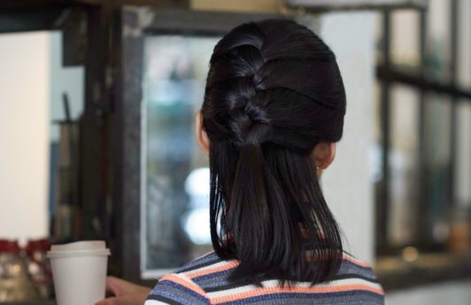 Wanita asia dengan rambut bob hitam pendek gaya French braid half updo