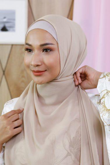 Wanita Asia merapikan hijab pashmina sifonnya.