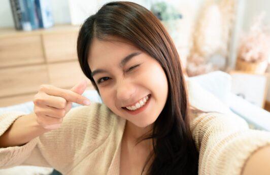 Wanita Asia berambut panjang sedang selfie sambil berkedip