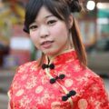 wanita asia dengan rambut dicepol dua dan mengenakan baju khas imlek