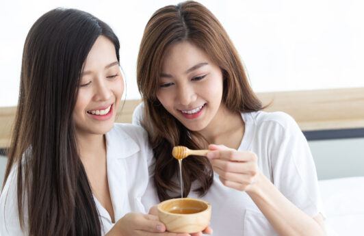 wanita asia sedang melakukan perawatan alami dengan madu untuk mengatasi ketombe
