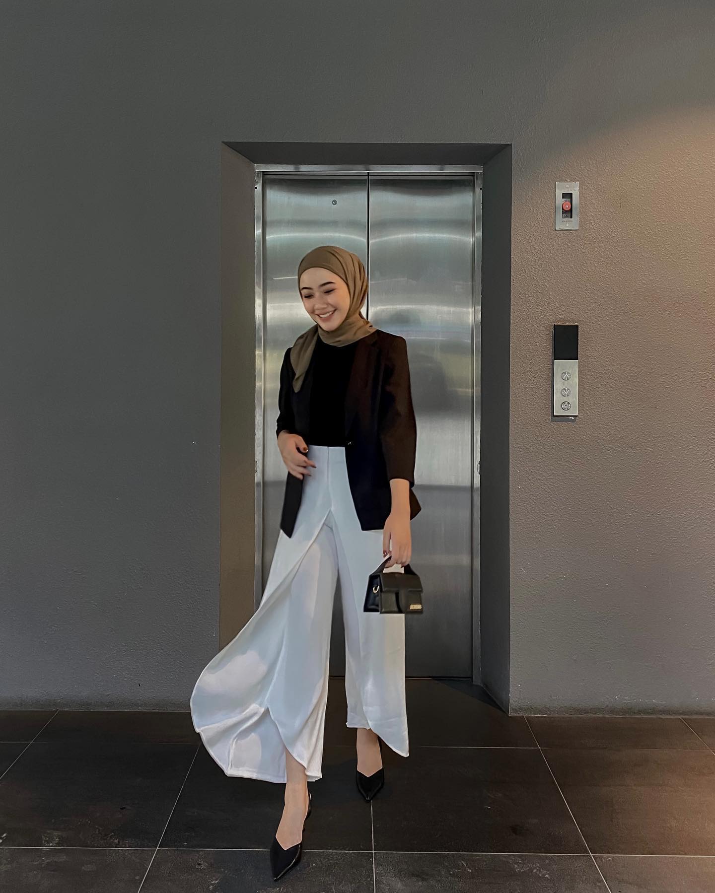 Wanita Indonesia dengan gaya smart kasual hitam putih.