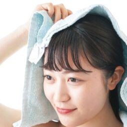 Wanita Asia sedang mengeringkan rambut menggunakan handuk