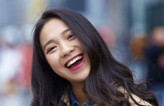 Wanita Asia berambut panjang sedang tertawa gembira