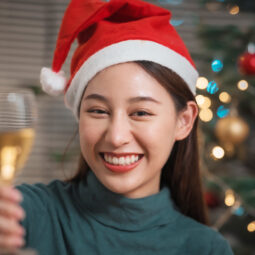 wanita asia dengan topi santa sedang merayakan natal