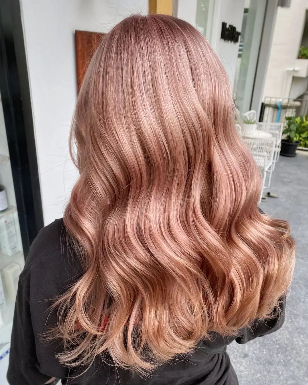 wanita dengan rambut panjang bergelombang warna pastel rose gold