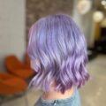 wanita dengan rambut pendek bergelombang warna pastel lavender