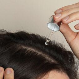 wanita sedang menggunakan hair tonic pada kulit kepala