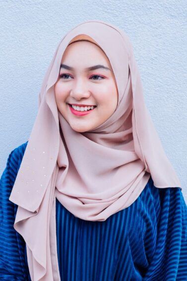 Wanita Asia mengenakan hijab pashmina gaya Malaysia.