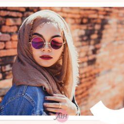 Wanita Asia mengenakan hijab pashmina crinkle warna cokelat dan kacamata hitam bulat.