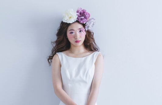 Wanita Asia dengan gaya rambut panjang bergelombang dengan hiasan bunga-bunga di atas kepala