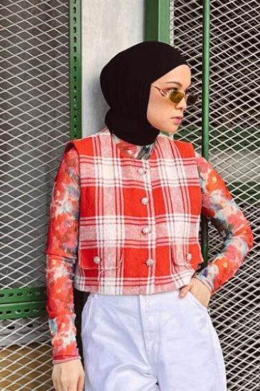 Tantri Namirah berpose berdiri mengenakan atasan motif merah putih dan celana panjang putih serta jilbab hitam.