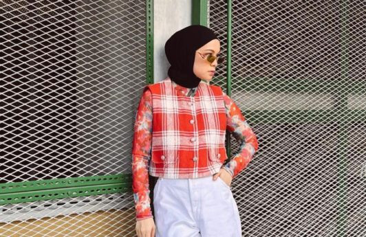 Tantri Namirah berpose berdiri mengenakan atasan motif merah putih dan celana panjang putih serta jilbab hitam.