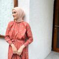 Wanita Indonesia mengenakan warna jilbab cream dengan dress warna orange salmon atau salem.