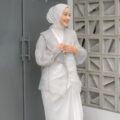 Wanita Indonesia berhijab putih kenakan baju putih dan luaran berbahan organza transparan.