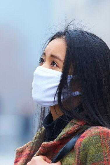 wanita asia sedang memakai masker karena polusi udara