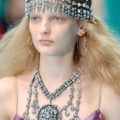 Mujer rubia de cabello suelto -parece algo frizzado- con una semi corona de strass