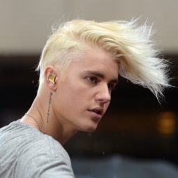 Justin Bieber con cabello rubio platinado, rapado de un lado y con un jopo larguísimo hacia adelante