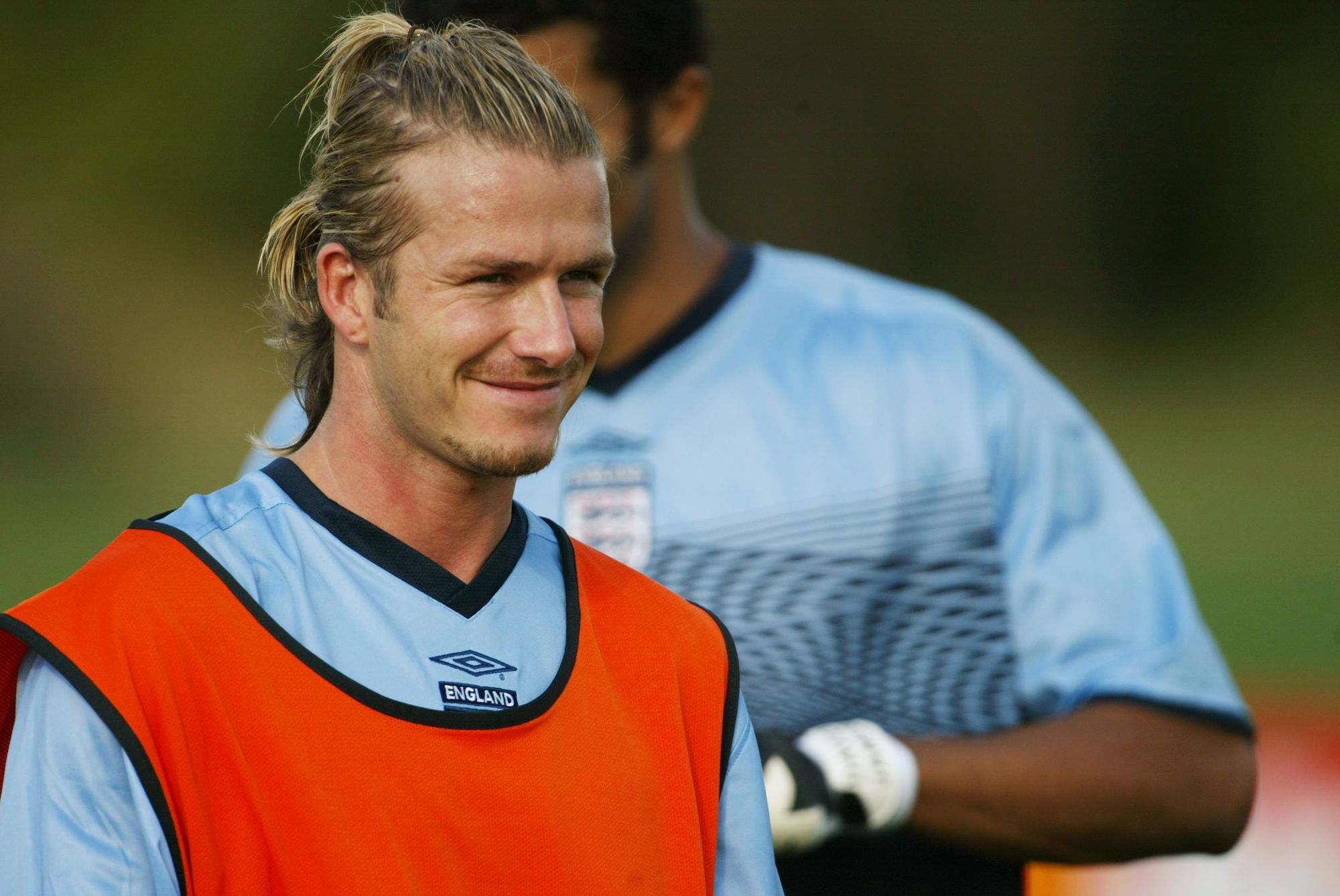 David Beckham en un entrentamiento de fútbol con cabello rubio recogido hacia atrás