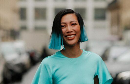 mujer asiatica de pelo corto tipo bob lacio negro con puntas de color turquesa, pelo turquesa