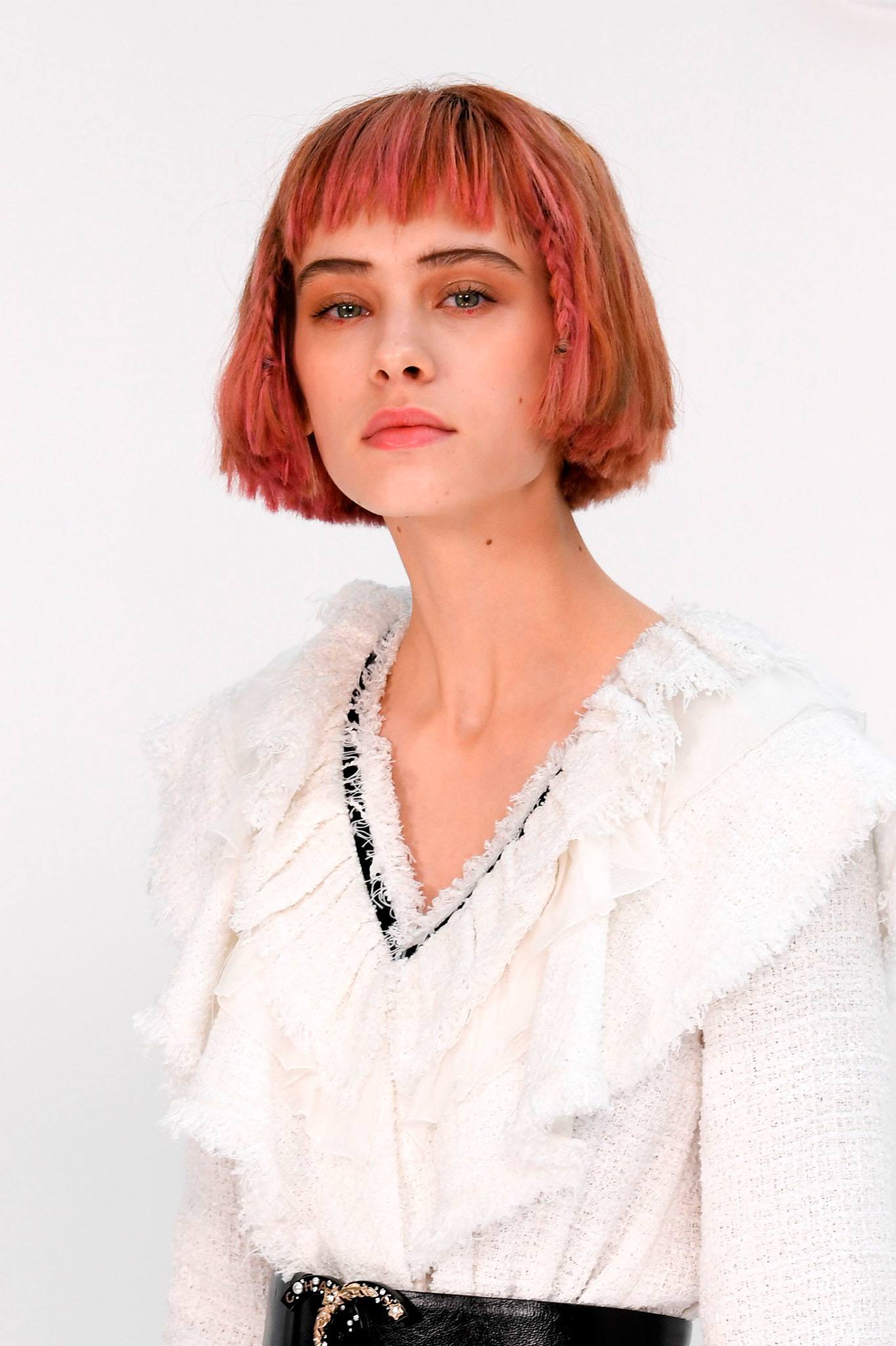 mujer blanca de pelo corto rosa con flequillo y trenzas mini adelante, peinados faciles para pelo corto