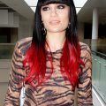 Jessie J con flequillo recto y pelo largo lacio color negro y mechas rojas en las puntas