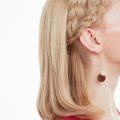 mujer de perfil con pelo corto rubio lacio y semirecogido con dos trenzas vincha, peinados cabello corto para fiesta