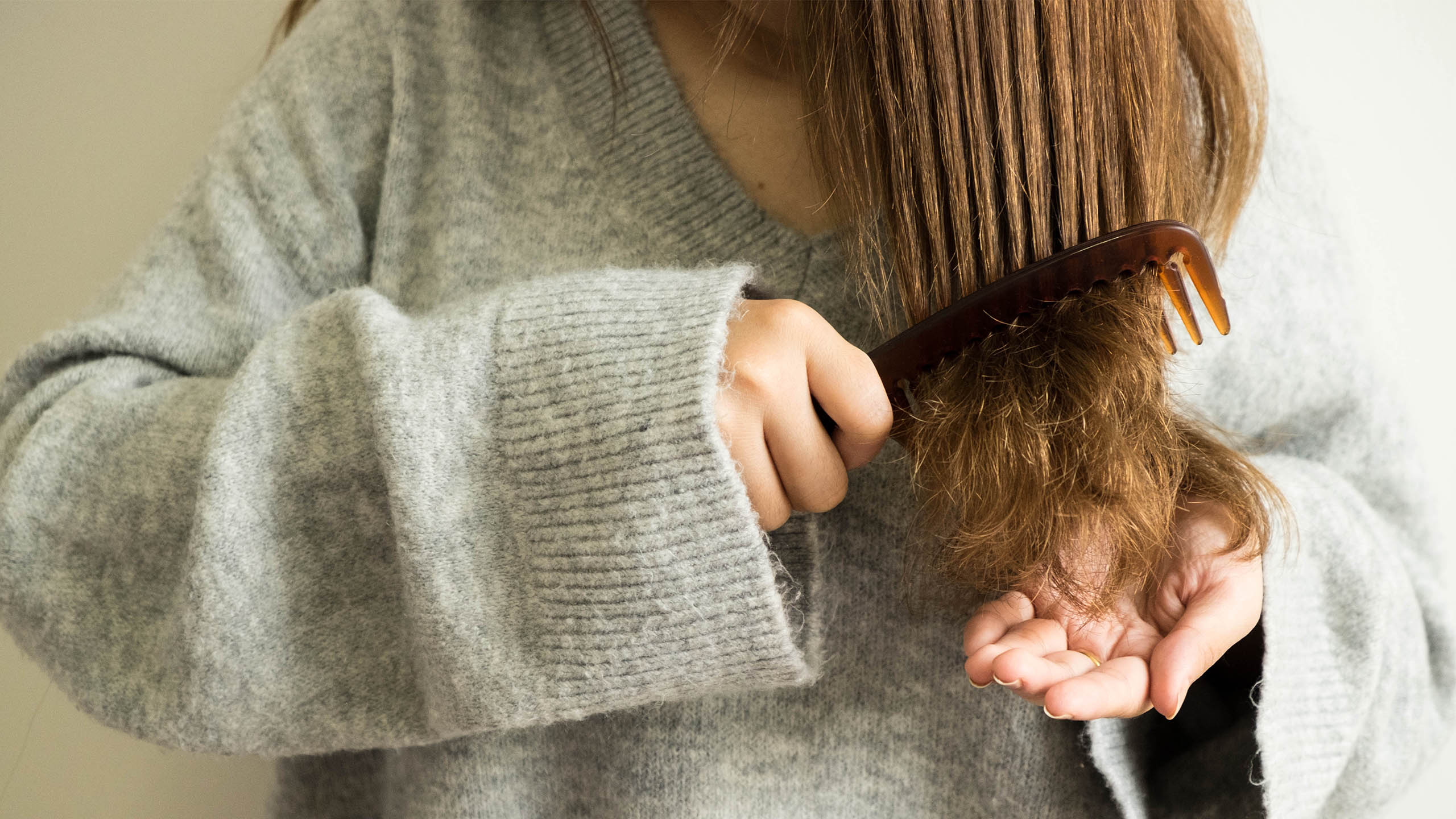 detalle de mujer peinando las puntas del pelo duro