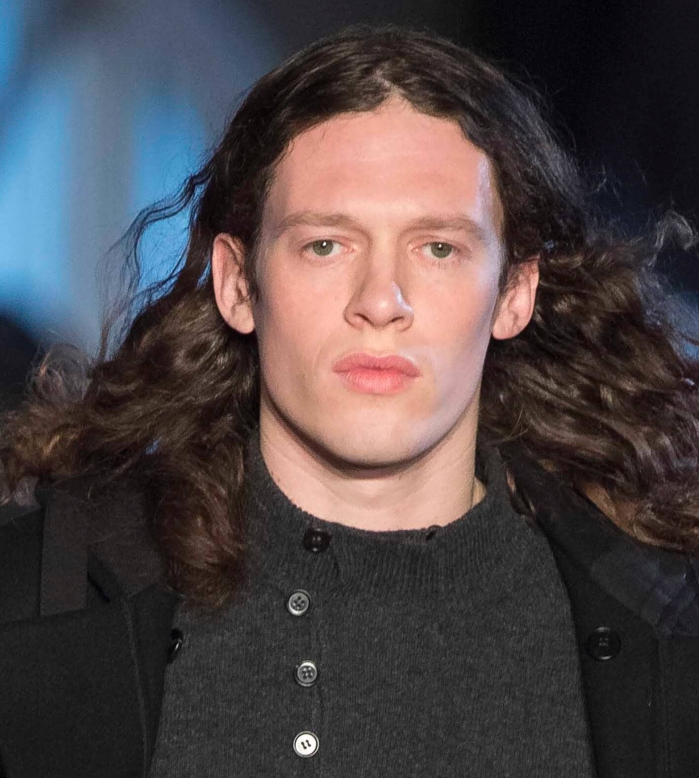 Man with long brown hair on runway.