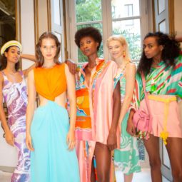 Shampoo: Five models backstage at Pucci SS19 show with different hair types and textures, from straight brown to short afro hair. All Models wearing bold coloured outfits.
