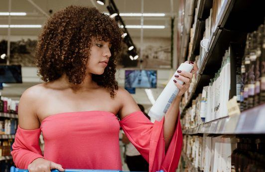 woman with curly hair looking at a hair product