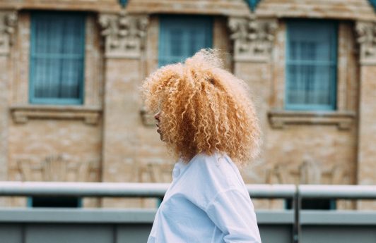 woman with big blonde afro curly hair natural hairstyle