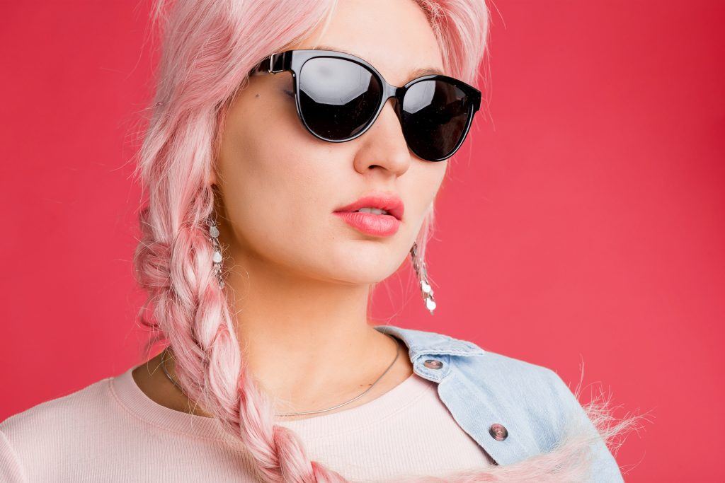 woman with dark sunglasses and pastel pink plait braid