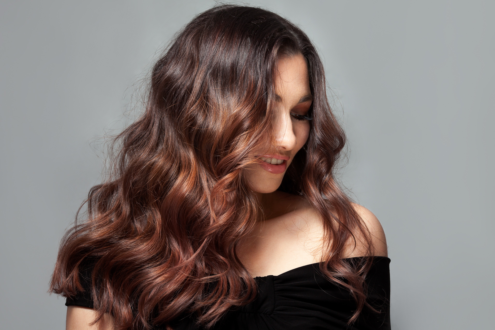 woman with long wavy brown hair lowlights full body wave perm