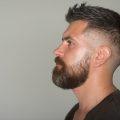 man with a quiff hairstyle and fade, with a big beard