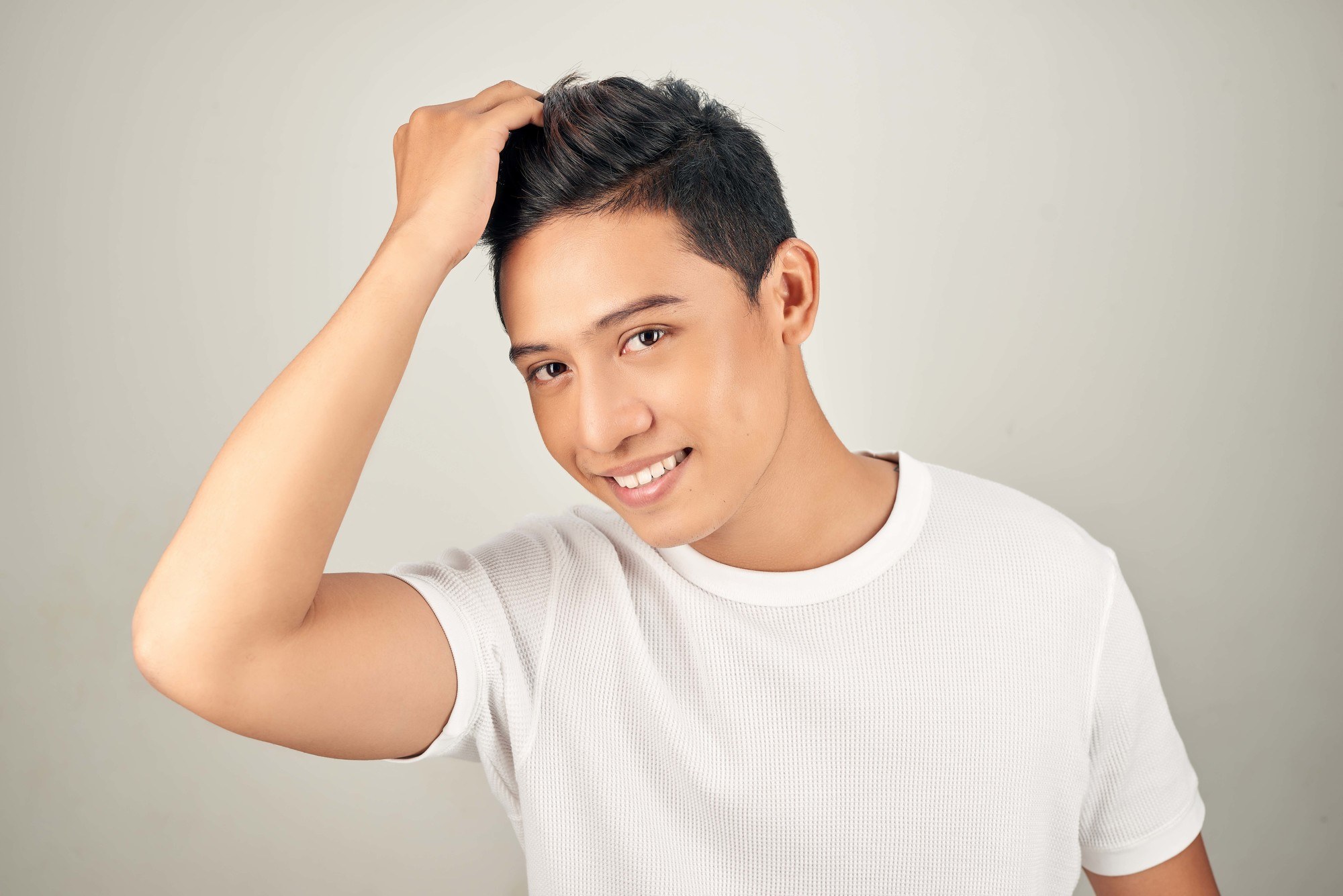 man tousling his short hair