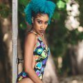 curly hairstyle: woman with a curly fauxhawk hairstyle, dark roots and bright blue curly hair