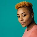 woman with short, light brown kinky curly hair and shaved sides