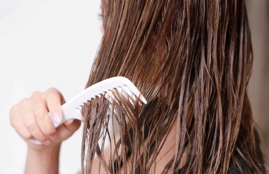 heat damaged hair: close up shot of combing through hair