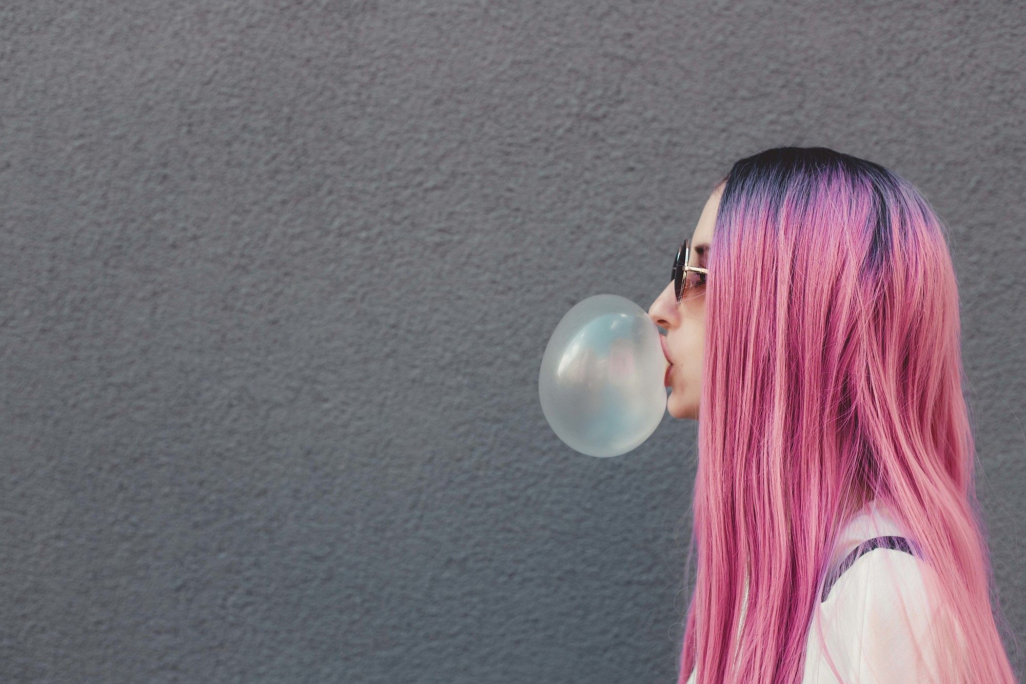 woman with pink hair and dark roots