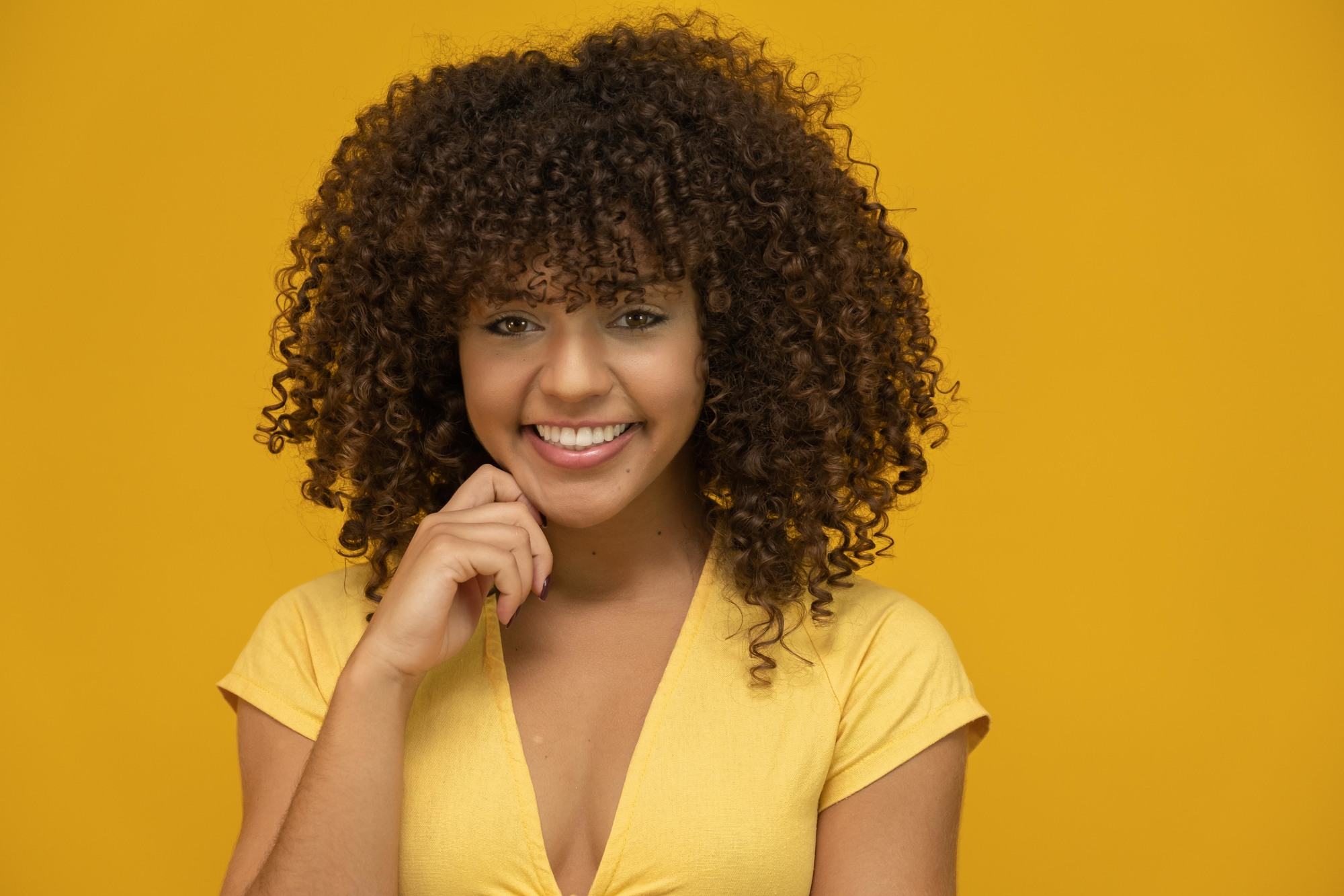 Woman with voluminous curly hair and bangs