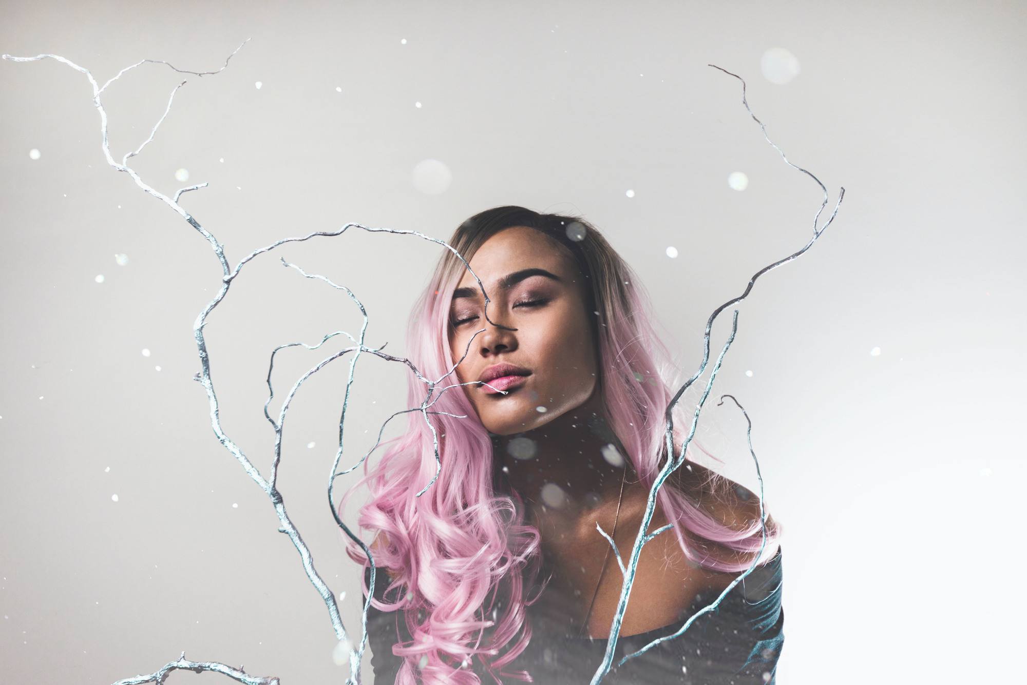 woman with long wavy hair, dark roots and pastel pink hair