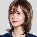 vintage haircuts: woman with sleek shoulder-length haircut that has layers and is curled in at the ends