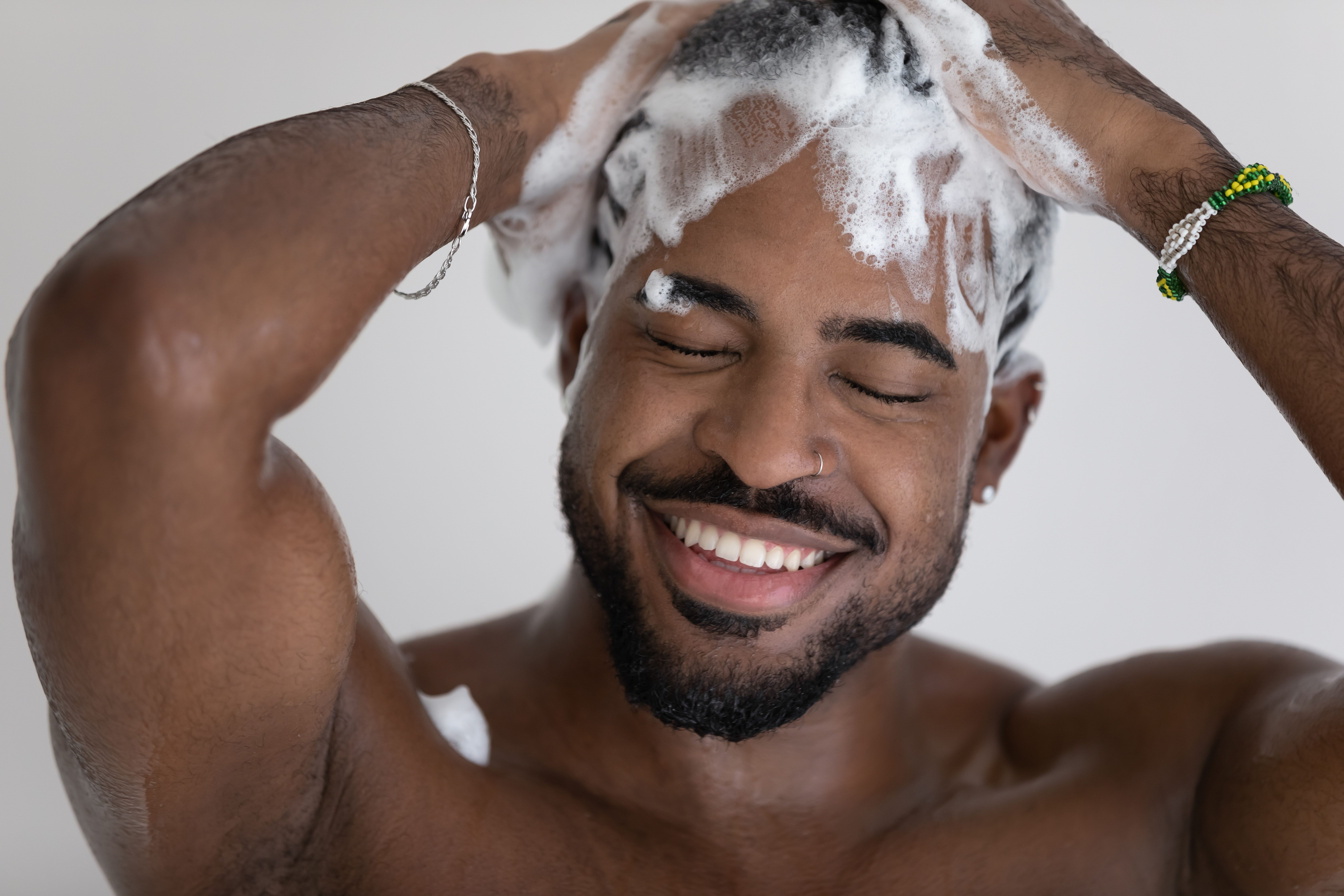 streamlined haircare routine: man washing his hair with shampoo