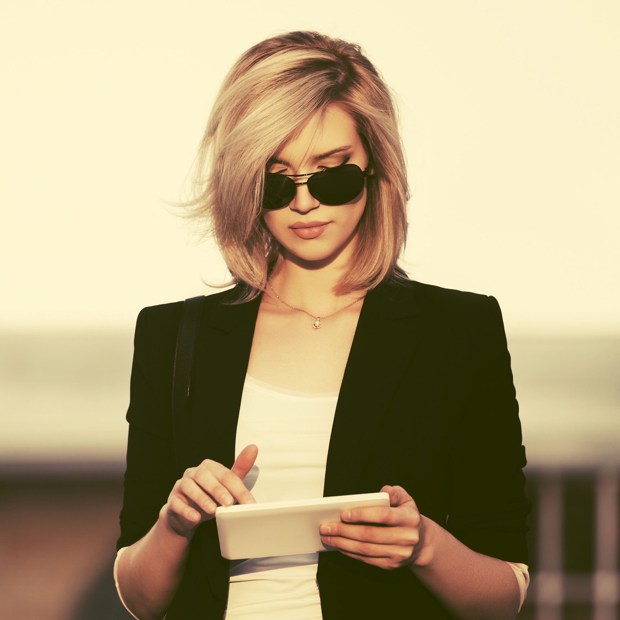 blonde bob hairstyle: woman with a sleek bob with a side path
