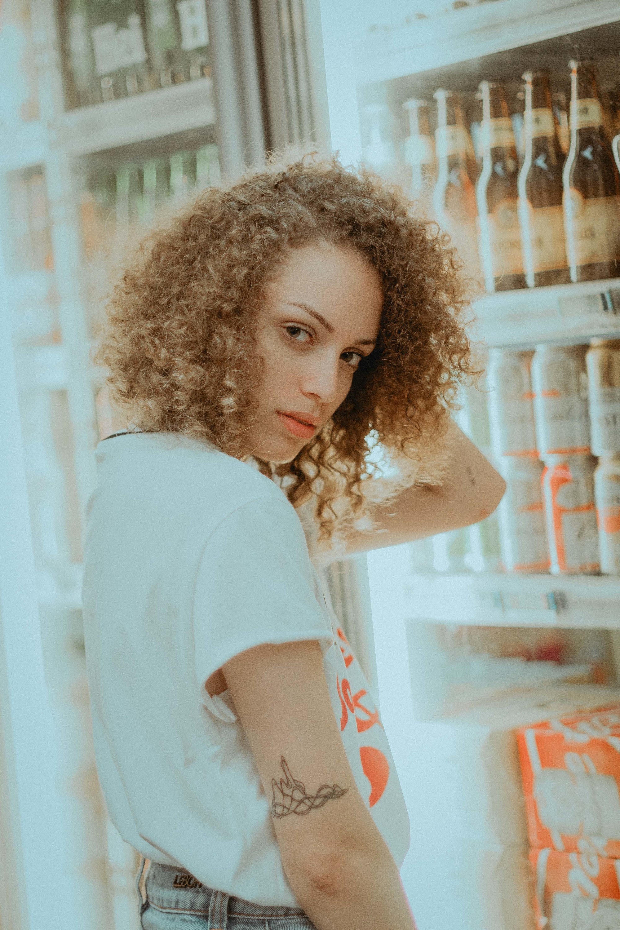 woman with a naturally curly, honey blonde bob hairstyle