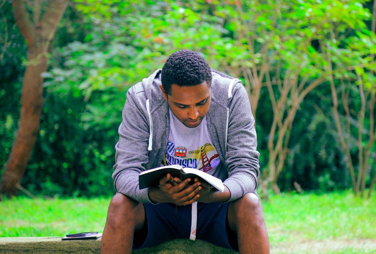 mental health awareness: man sitting in a park, reading a book