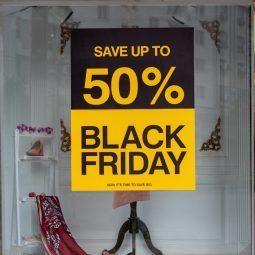 image of a shop window with a big black and yellow sign that says 